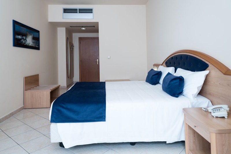 Camera della residenza UNI+ BLU con letto e testiera imbottita blu
