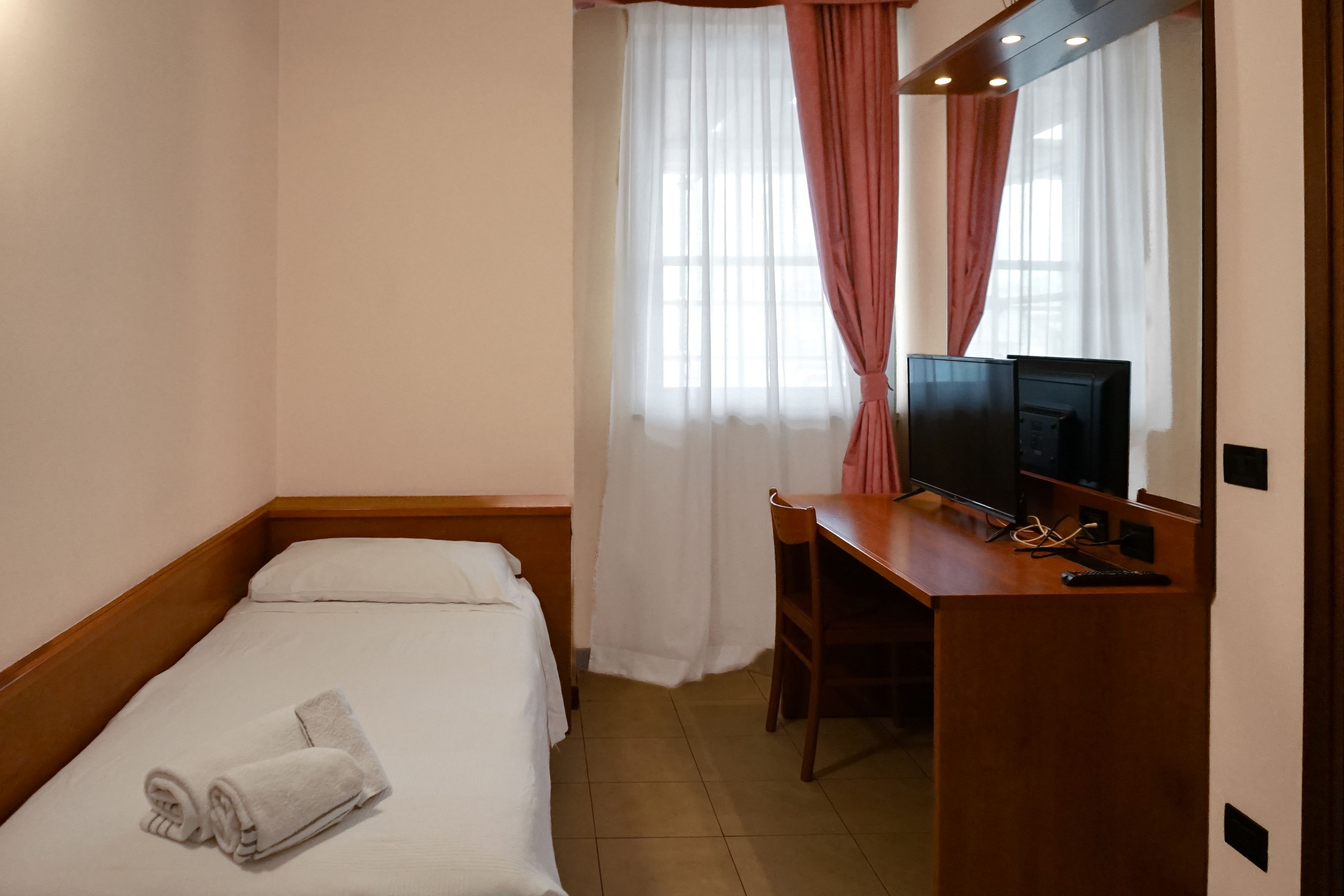 Camera singola con letto, scrivania e televisore